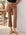 Brown latte Sigourney Pintuck Pants in faux leather with pintuck detailing and flared cropped legs