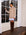 Woman wearing Carrie Mixed Media Dress with wheat sweater overlay and white with blue striped shirttail hem, paired with brown knee-high boots.
