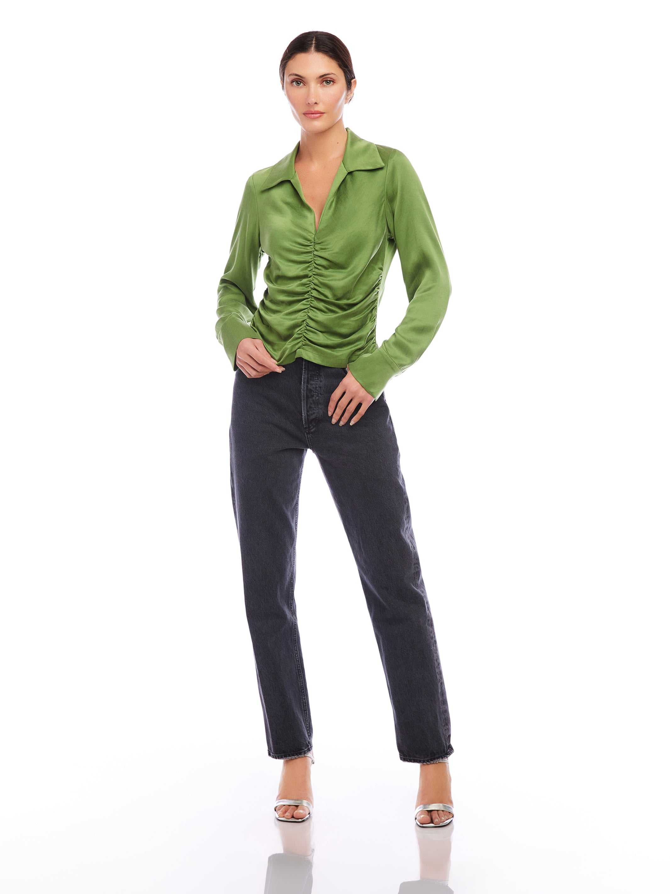 Woman wearing green Arabella Shirred Top with collared V-neck and cuffed long sleeves paired with dark jeans.