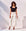 Woman wearing black Mindy T-Shirt with square neck and short sleeves paired with white pants and sunglasses outdoors